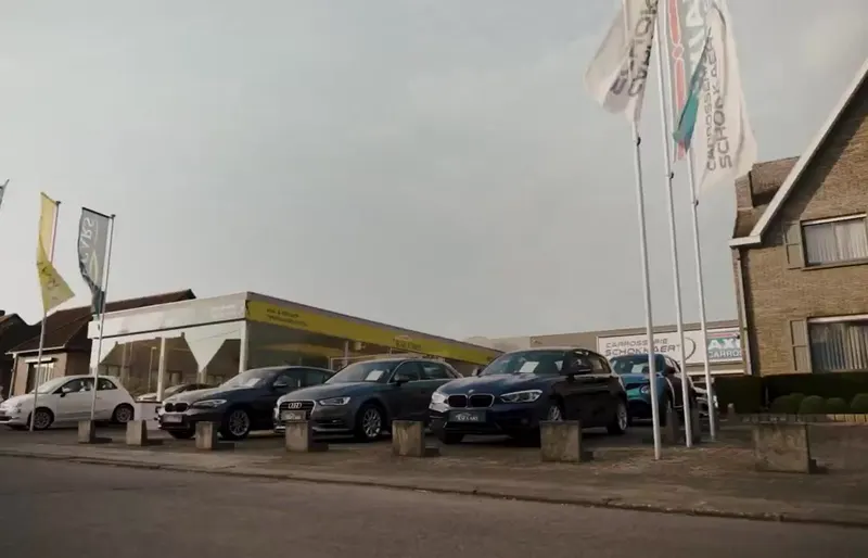 Het terrein van Raf Cars in Ninove-Outer met wagens en vlaggen